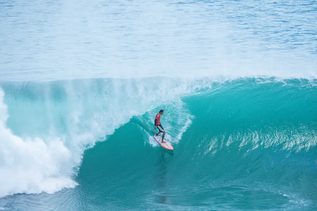 advanced surfer surfing in the barrel of a wave in Uluwatu, Bali.