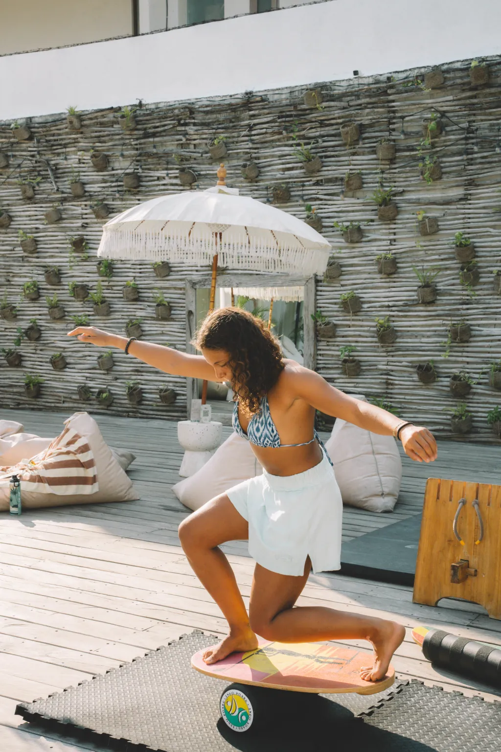 A guest at Kima Surf Canggu practicing her balance on a balance board