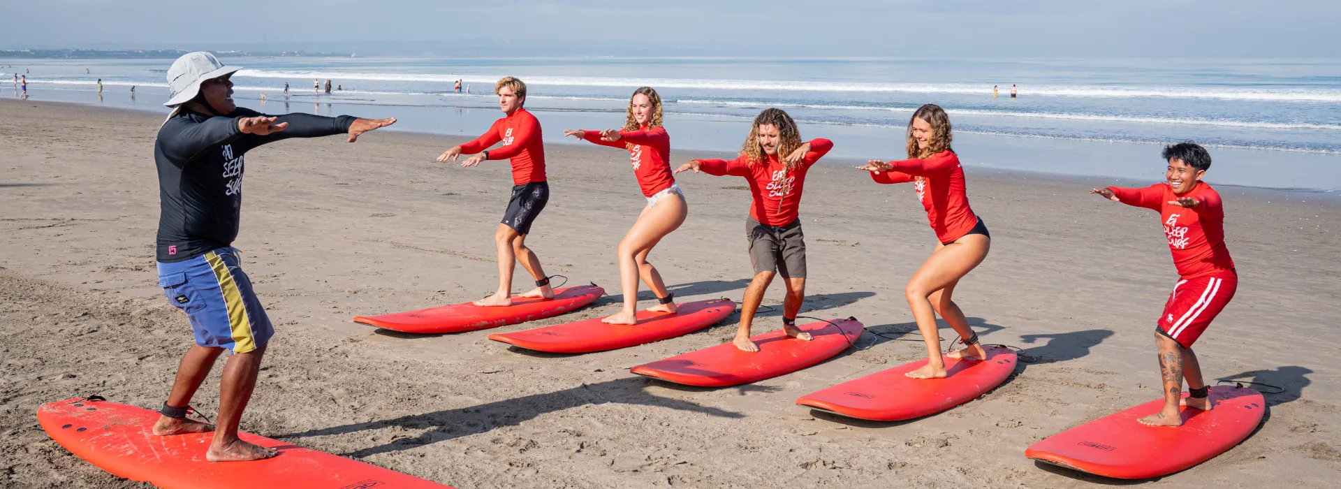 beginner surfers practicing their pop-up on dry land