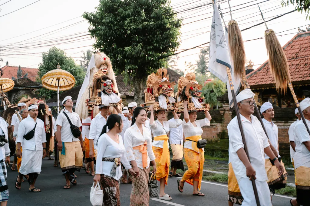 Balinese people in traditional clothing participating in a religious ceremony.