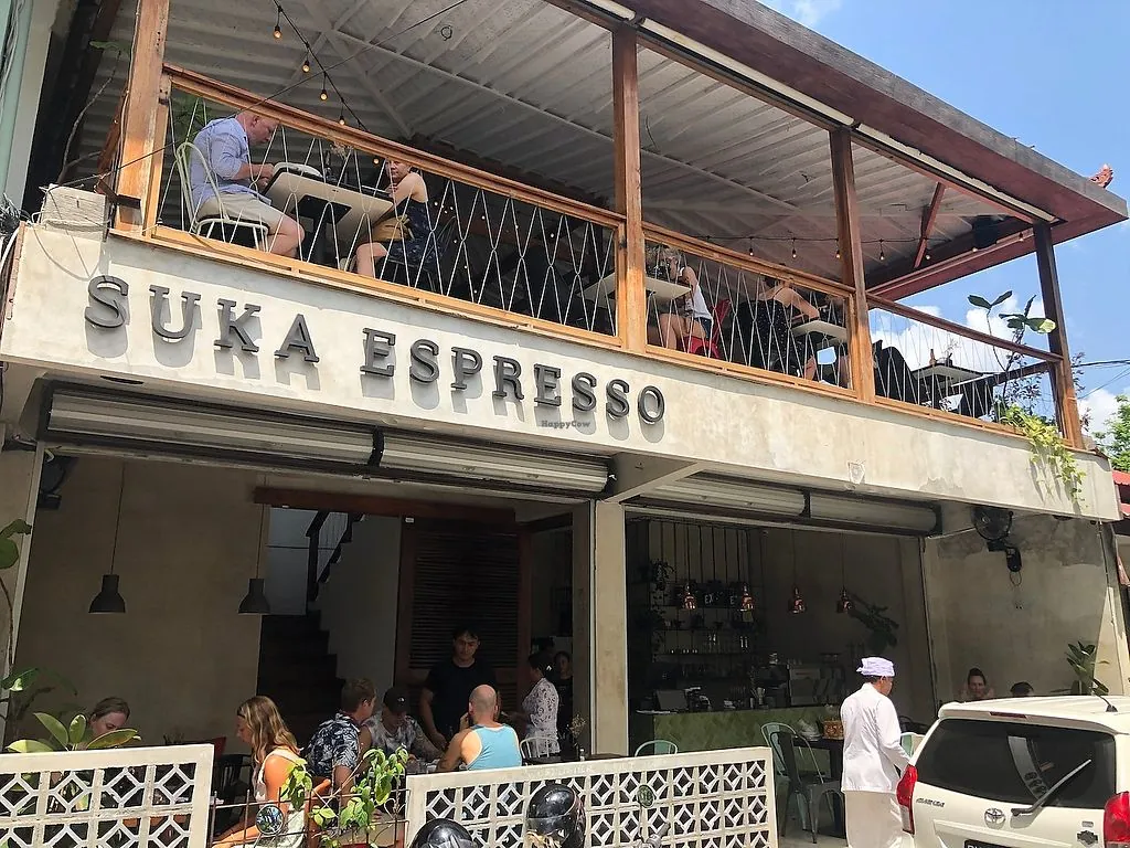 Suka espresso photographed from the front, double story cafe with people enjoying food and drinks