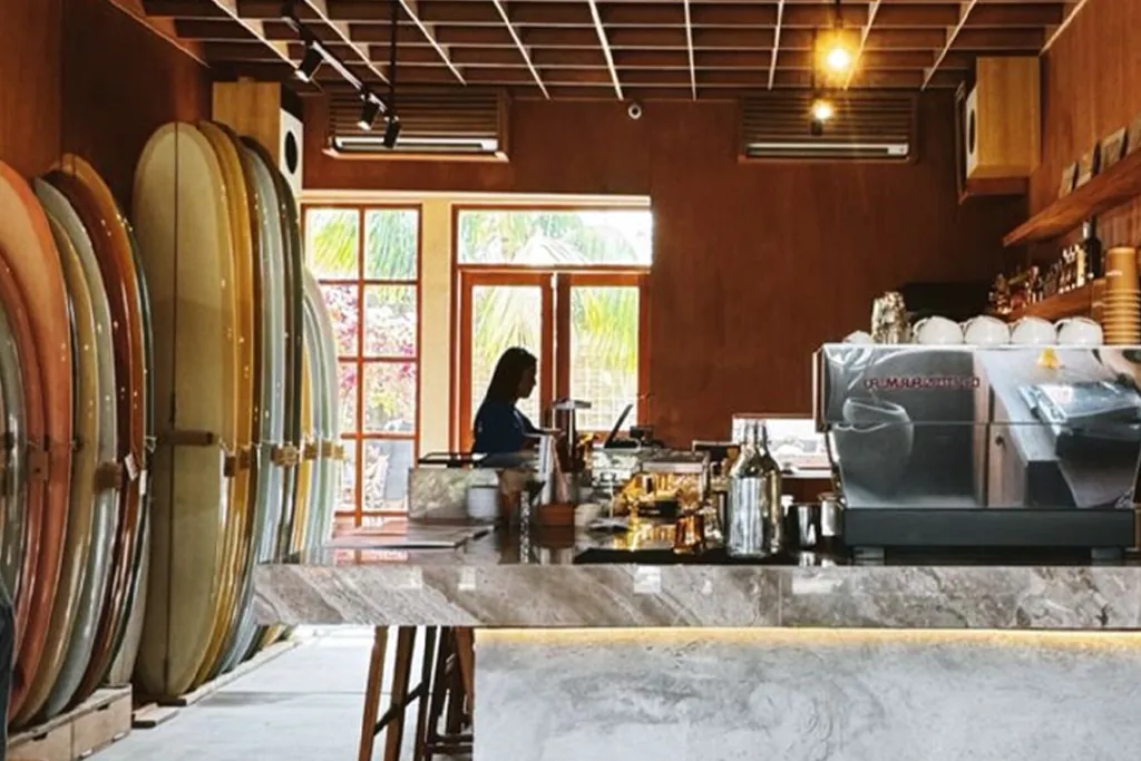 surfboards lined on the left and coffee machine and bar on the right.