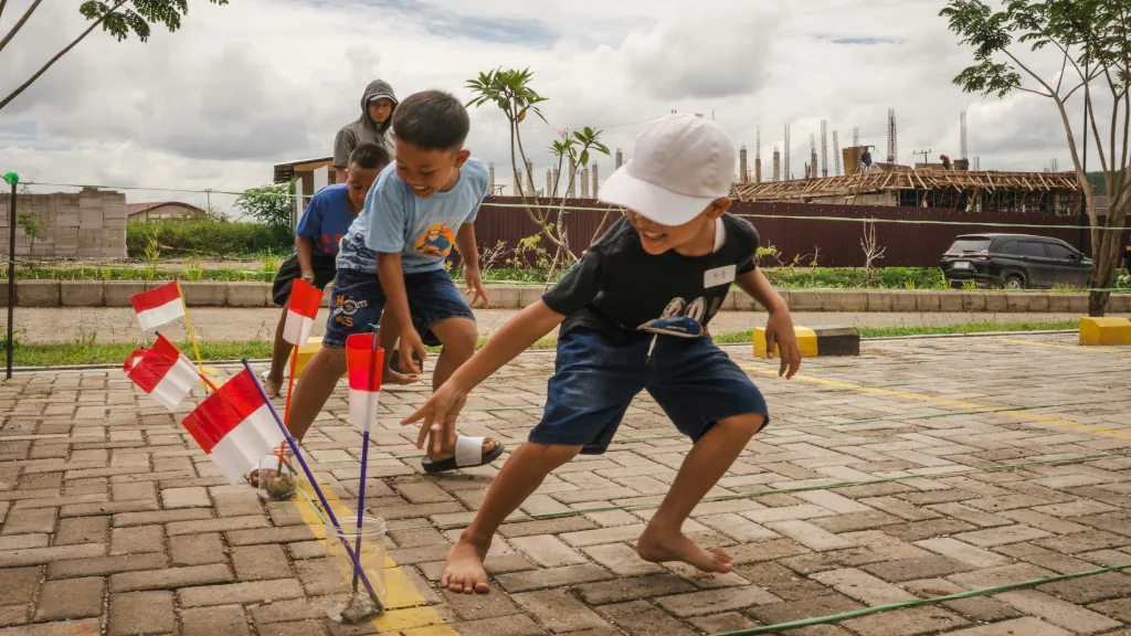 children playing a game with Indonesian flags