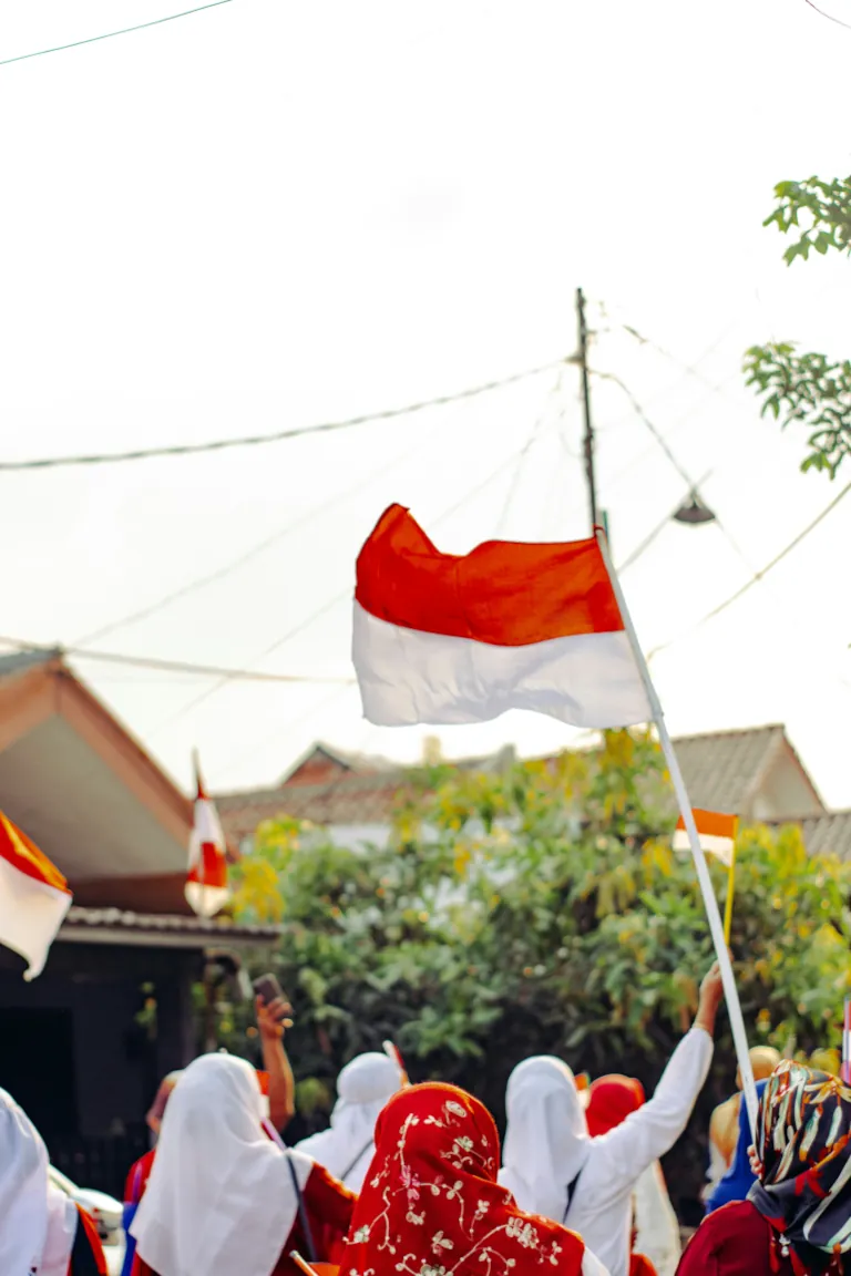 a few people holding Indonesian flags in a crowd