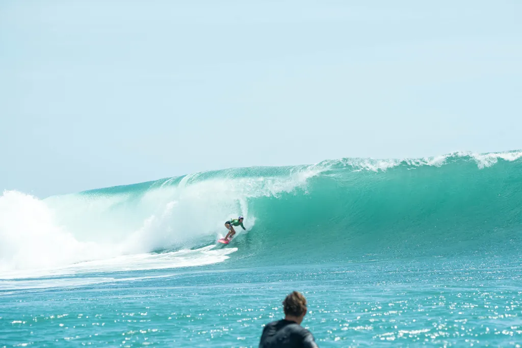 a woman riding a wave about to barrel.