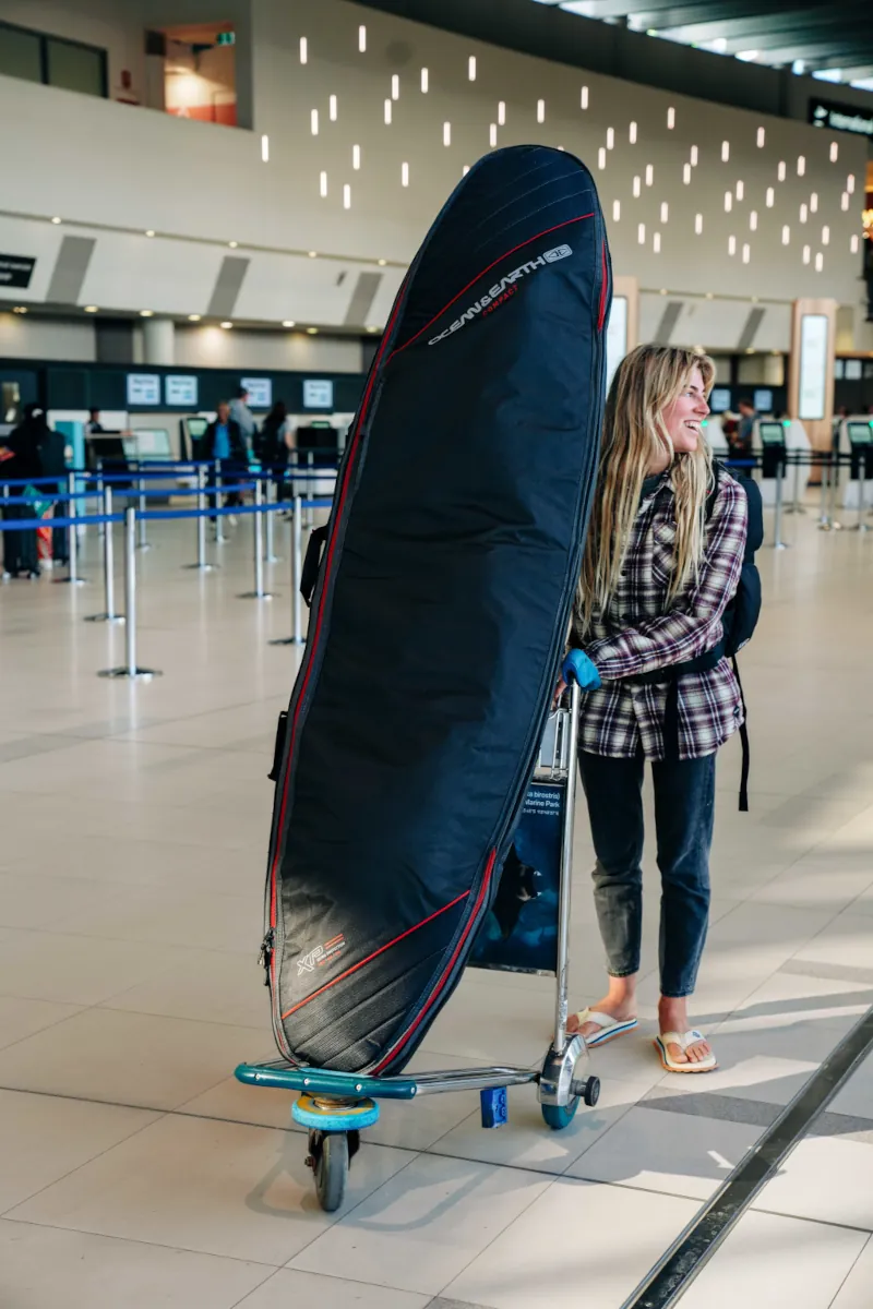 Surfer with her boardbag at departures at the airport