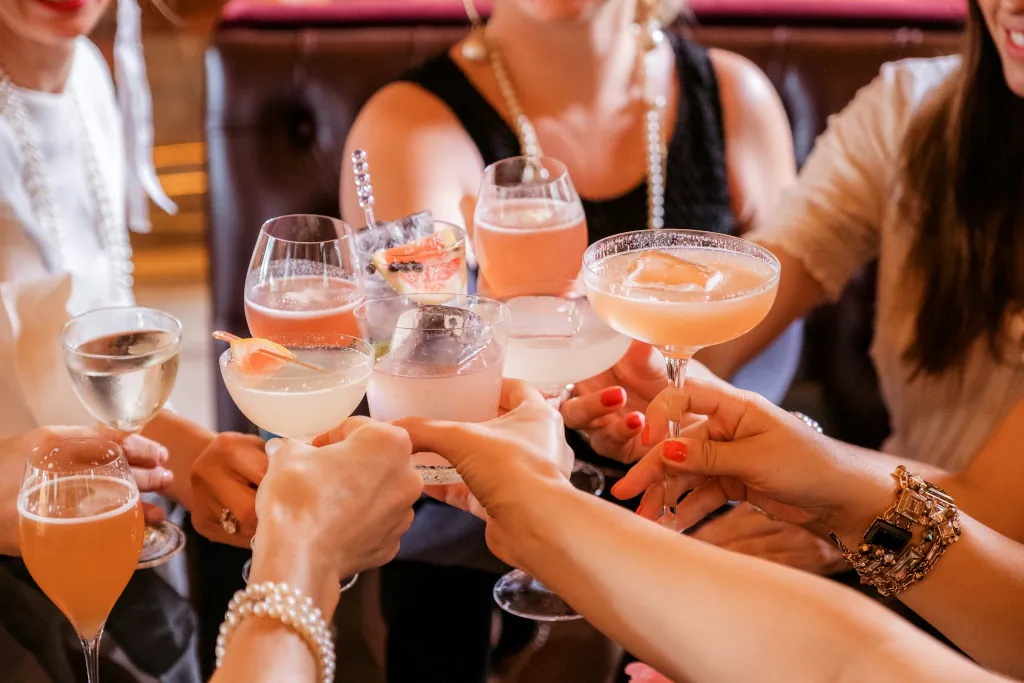 WOMAN CHEERS WITH COCKTAILS