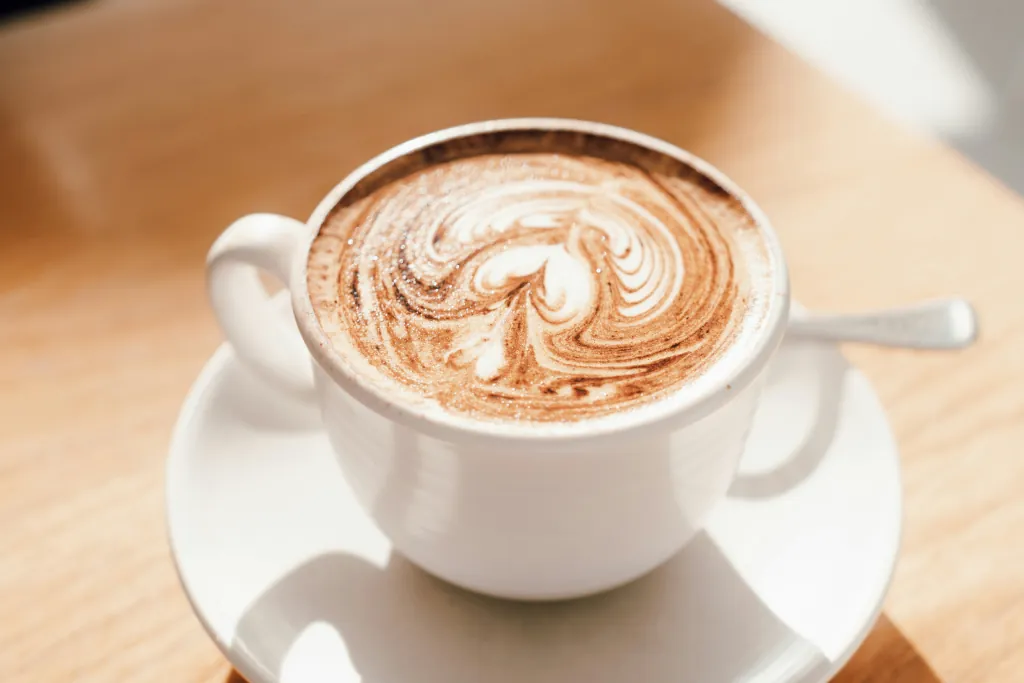 A CAPPUCINO IN A WHITE CERAMIC CUP