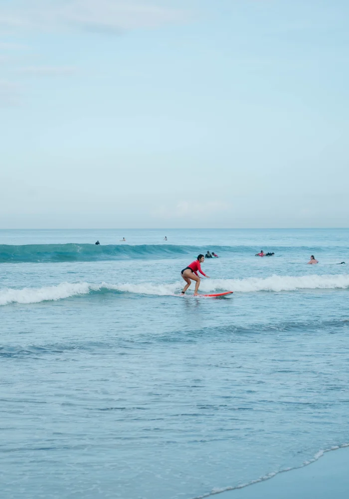 a beginner surfer catching a white water wave