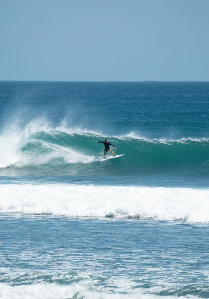 an intermediate surfer on an overhead wave