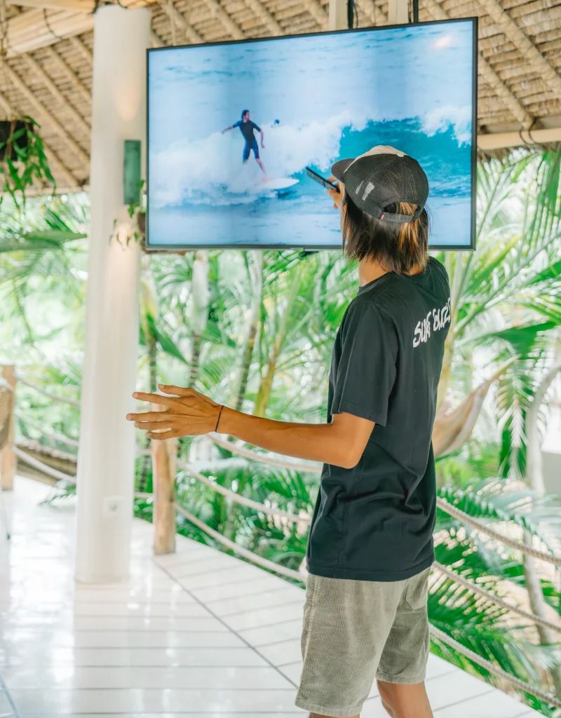 a surf guide giving feedback on the video of a wave