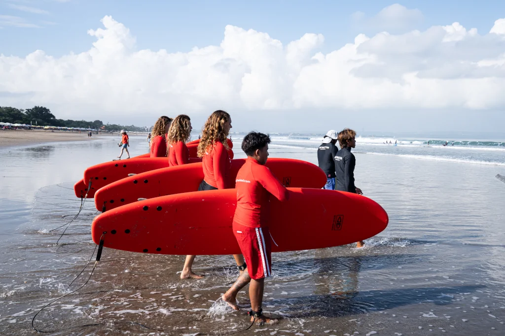SURFERS HOLDING SOFT-TOP SURFBOARDS