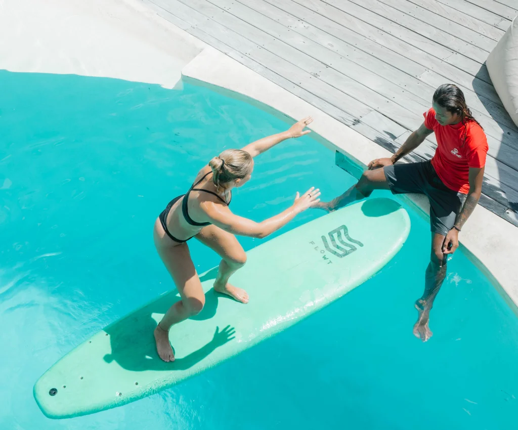a surf guide and student practicing the surf stance in the swimming pool