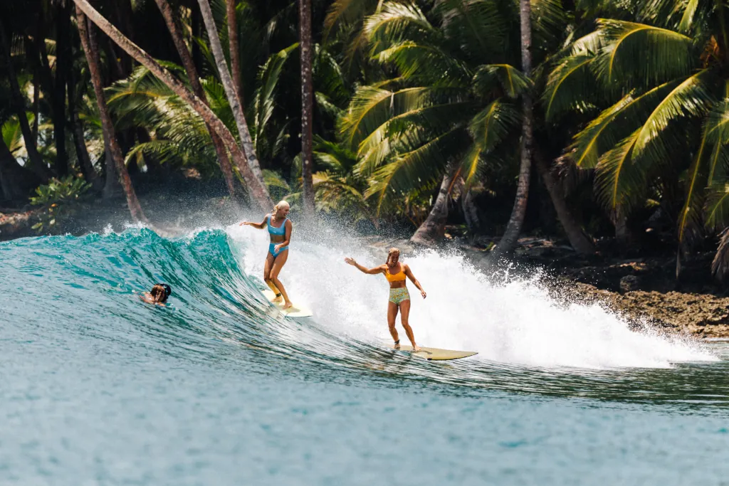 Two girls sharing a wave and smiling 