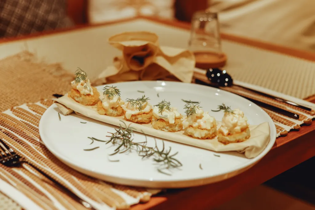 Gourmet canapés with fresh dill served on a plate on a set up dining table.