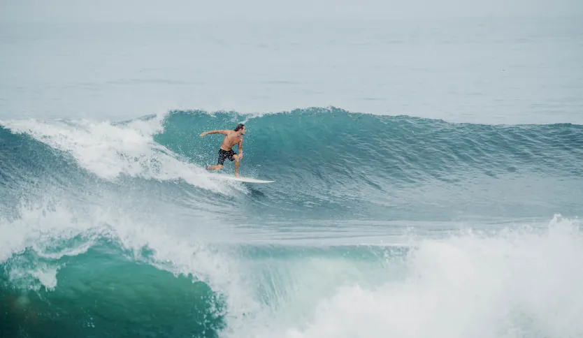 Ein erfahrener Surfer macht einen Front-Side-Turn an der Lippe einer großen Welle am berühmten Surfspot von Uluwatu